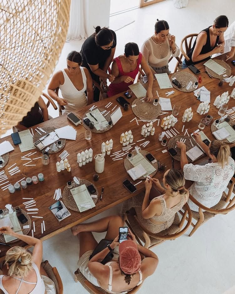 A group of women at a hands-on workshop around a long wooden table