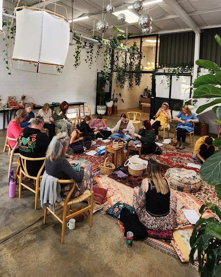 A group of women sitting on chairs and floor cushions in a circle