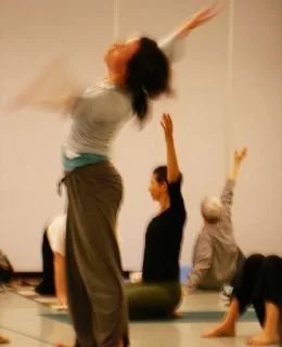 Group of people practicing yoga, stretching with arms raised