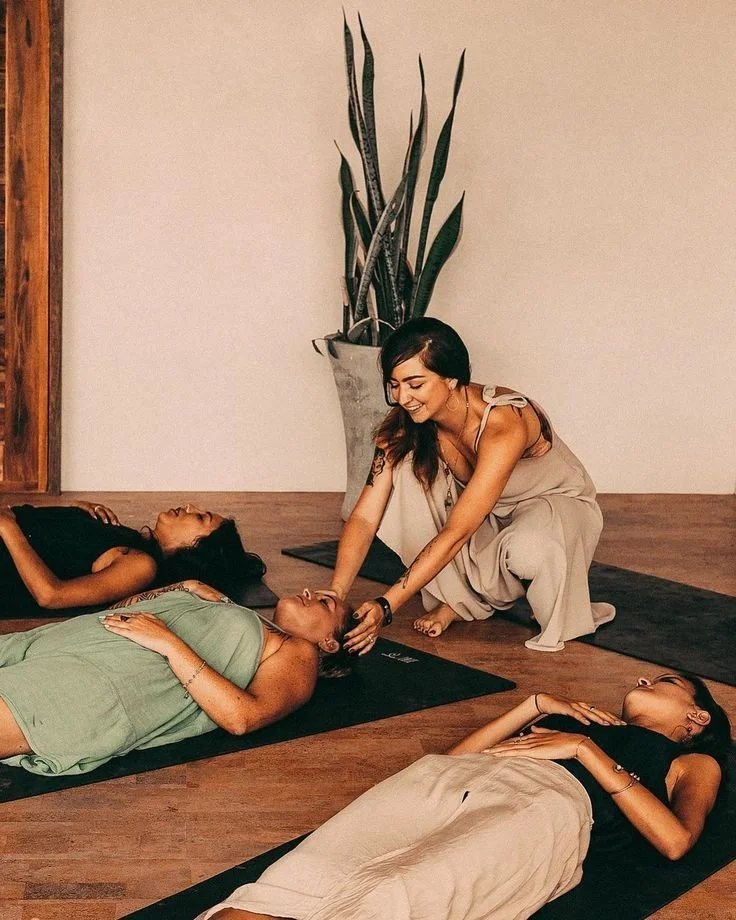 A woman leading a yoga or meditation class in a studio