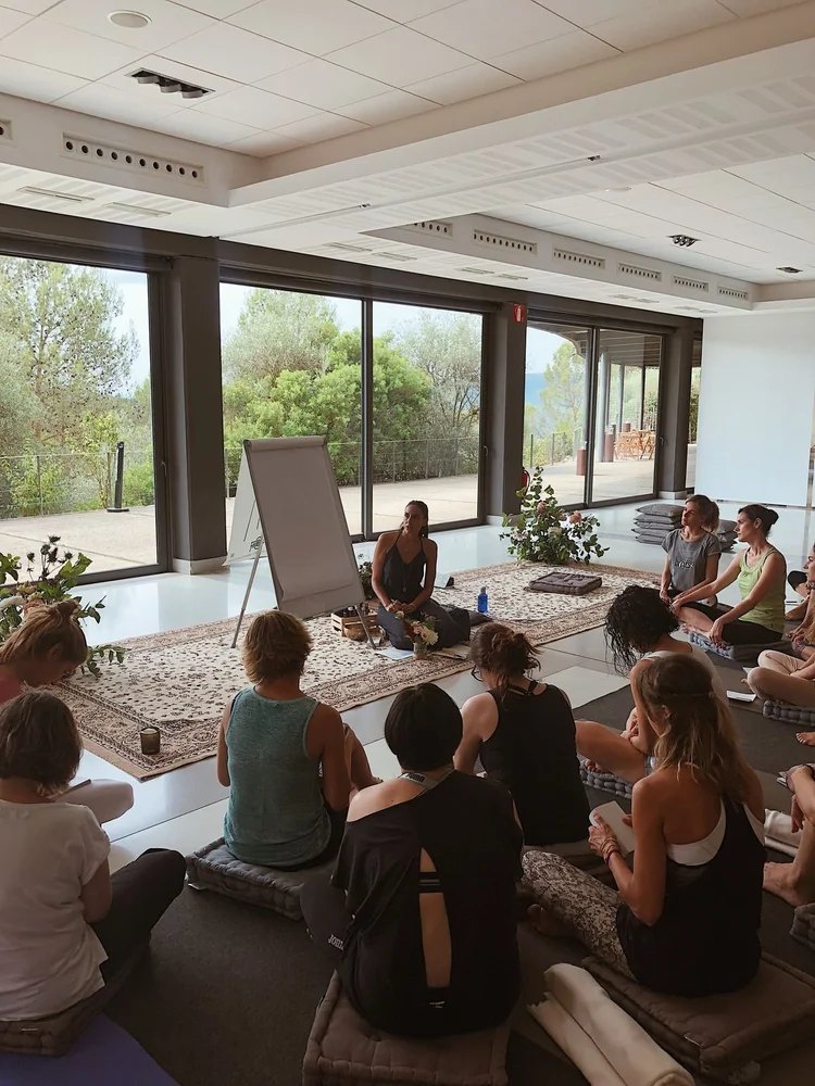 A group of people attending a meditation session in a bright room